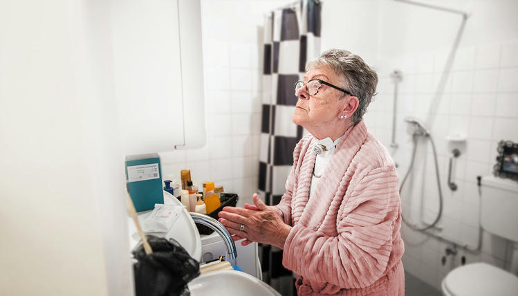 tracheostomy-care Woman caring for tracheostomy in bathroom